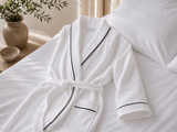White luxury bath robe with black trim in free size for hotels, Airbnb properties, furnished apartments, spas, and corporate housing.