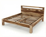 Angled view of solid Sheesham wood bed frame with natural grain headboard and wooden slats
