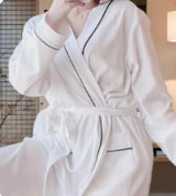 White luxury bath robe with black trim in free size for hotels, Airbnb properties, furnished apartments, spas, and corporate housing.