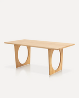 Modern solid ash wood dining table with an organic sculptural base featuring circular cutout details, designed for hotels, Airbnb properties, furnished apartments, and contemporary dining spaces.