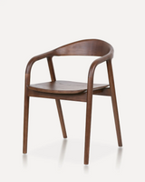 Modern solid ash wood dining chair with an ergonomic curved backrest, integrated armrests, and a natural wood finish for hotels, Airbnb properties, furnished apartments, restaurants, cafés, offices, and contemporary dining spaces.