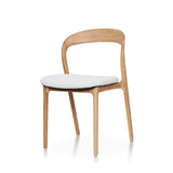 Curved Ash Wood Dining Chair handcrafted from premium solid ash wood, featuring a curved backrest, upholstered seat cushion, natural wood grain, and timeless contemporary craftsmanship.